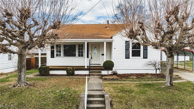 bungalow-style home with a front lawn, a shingled roof, and fence