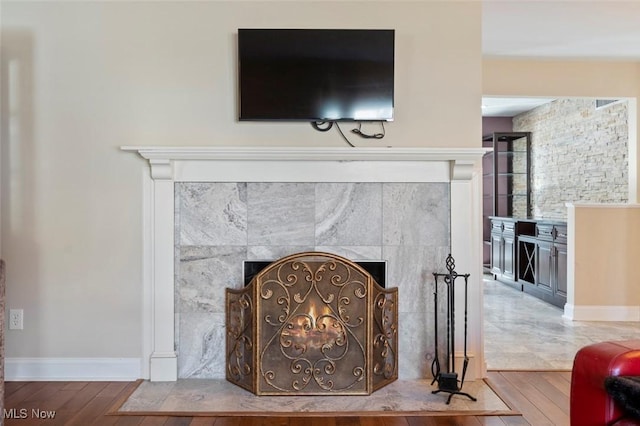 interior details with a fireplace, baseboards, and wood finished floors