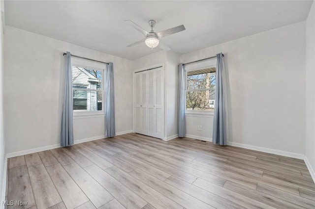 interior space featuring light wood finished floors, baseboards, and a wealth of natural light