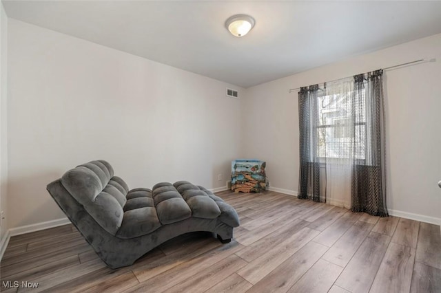 sitting room with baseboards and wood finished floors