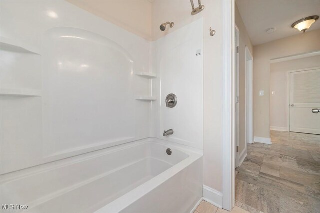 bathroom with shower / bath combination and baseboards