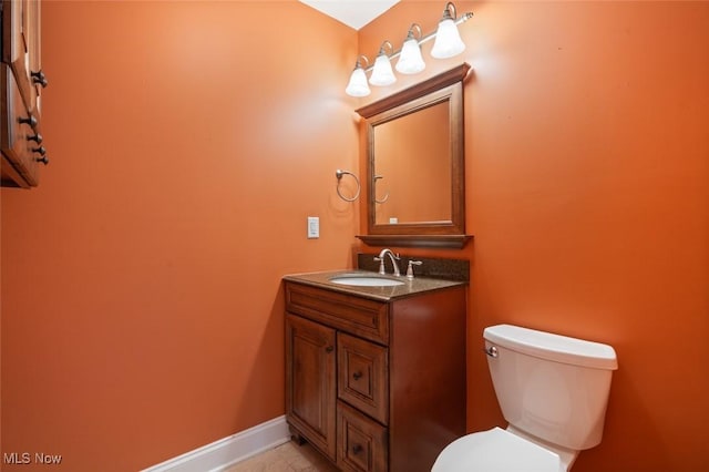 bathroom featuring vanity, toilet, and baseboards