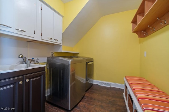 laundry room featuring cabinet space, dark wood-type flooring, a sink, separate washer and dryer, and baseboards