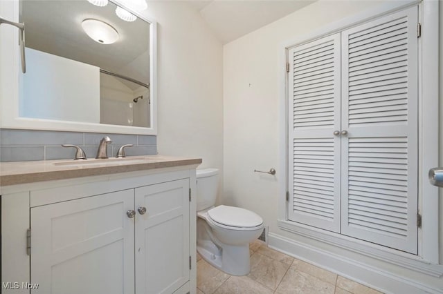 bathroom with a shower, backsplash, vanity, and toilet