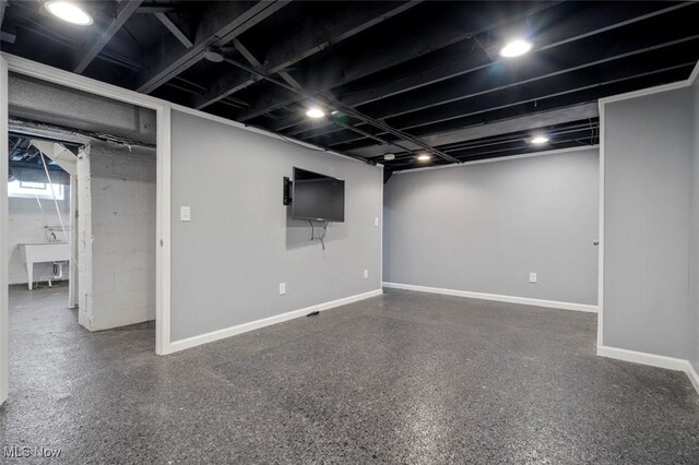 basement featuring a sink and baseboards