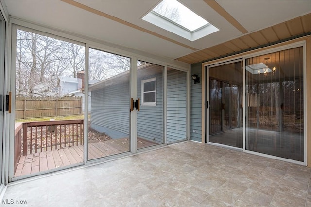 unfurnished sunroom featuring a skylight