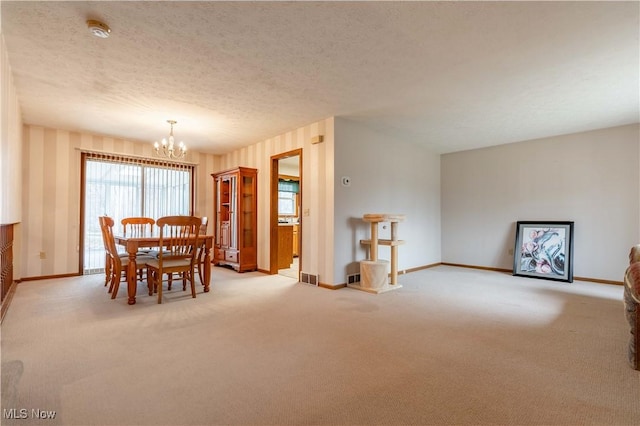 dining room featuring a notable chandelier, visible vents, a textured ceiling, and light colored carpet