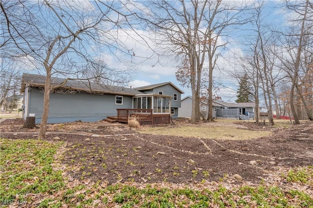 back of house featuring a sunroom and a deck