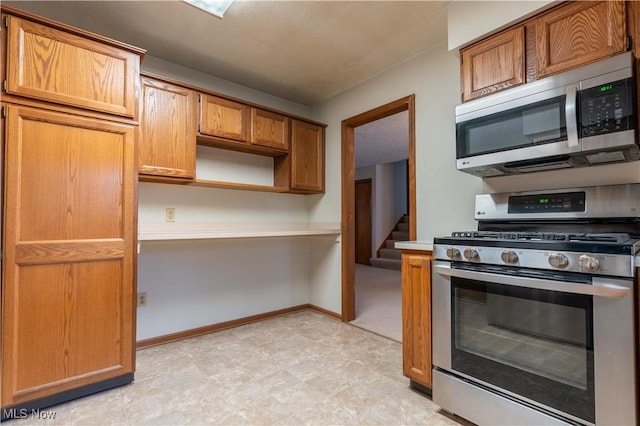 kitchen with open shelves, stainless steel appliances, light countertops, brown cabinetry, and baseboards