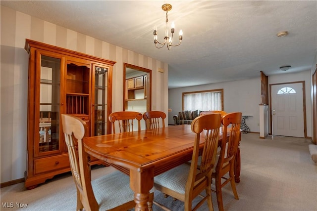 dining room with light carpet, baseboards, a notable chandelier, and wallpapered walls