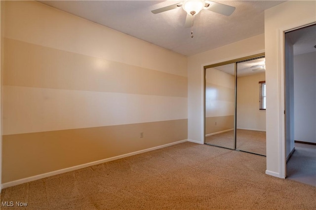 unfurnished bedroom with a closet, carpet flooring, a ceiling fan, and baseboards