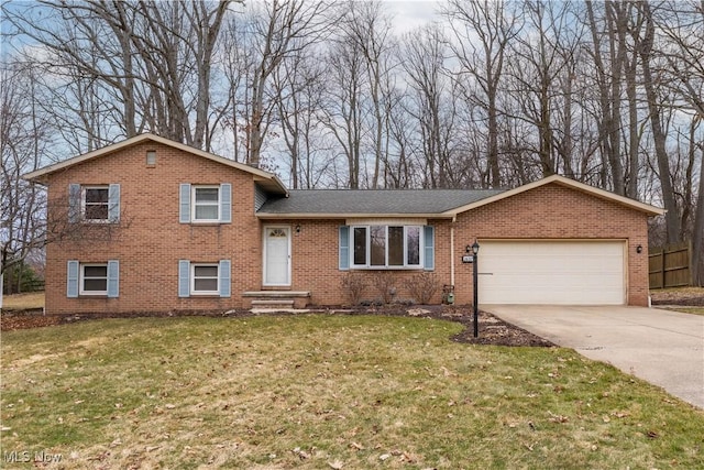 split level home featuring brick siding, roof with shingles, concrete driveway, a garage, and a front lawn