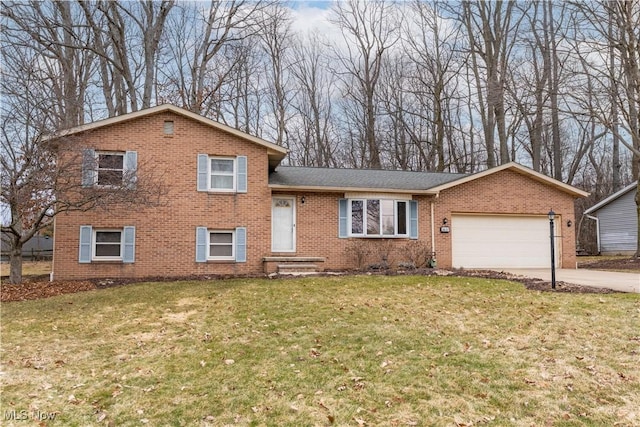 tri-level home featuring an attached garage, concrete driveway, brick siding, and a front yard