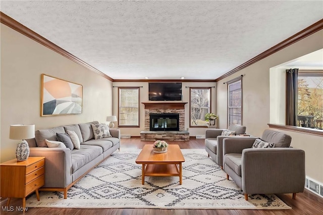 living area featuring a textured ceiling, a fireplace, wood finished floors, and visible vents