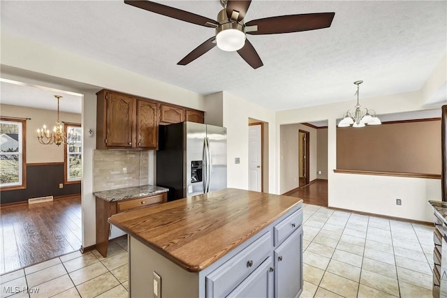 kitchen featuring hanging light fixtures, light tile patterned flooring, visible vents, and stainless steel fridge with ice dispenser