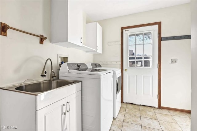 clothes washing area with cabinet space, light tile patterned flooring, a sink, separate washer and dryer, and baseboards