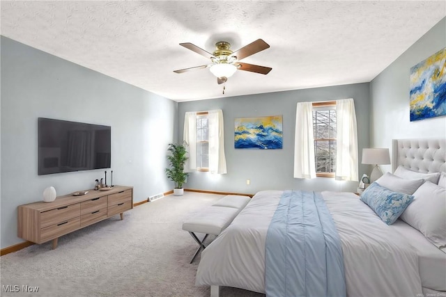 carpeted bedroom featuring visible vents, a textured ceiling, and baseboards