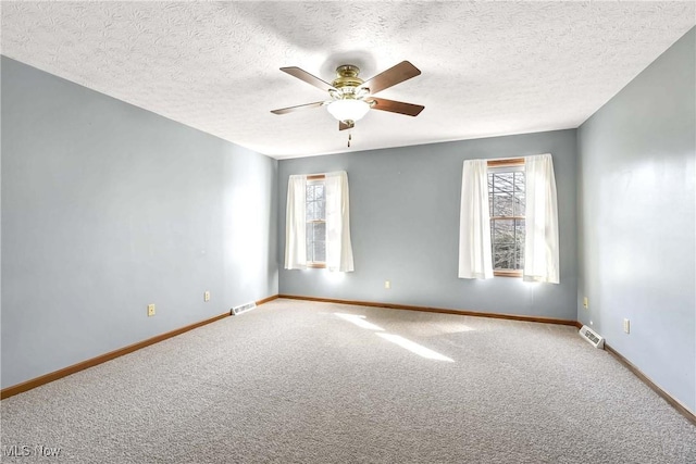 empty room featuring plenty of natural light, visible vents, and baseboards