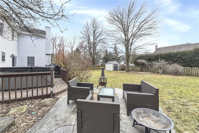 view of patio / terrace featuring a storage unit, a hot tub, a deck, an outdoor structure, and an outdoor living space