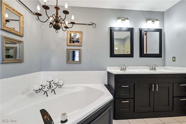 full bathroom with double vanity, a garden tub, a sink, and a notable chandelier