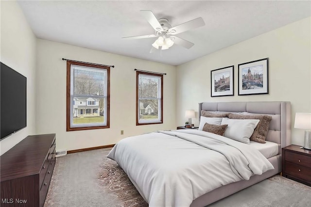 carpeted bedroom with ceiling fan and baseboards