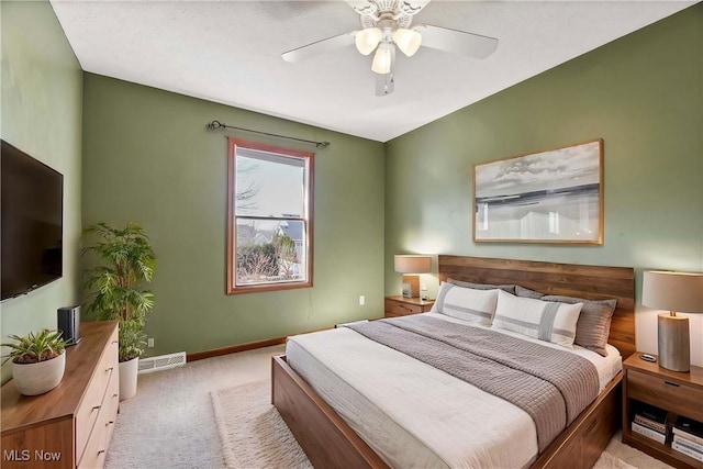 bedroom featuring light colored carpet, ceiling fan, visible vents, and baseboards