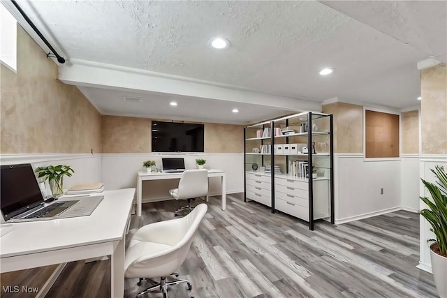 office area with a textured ceiling, wainscoting, wood finished floors, and recessed lighting