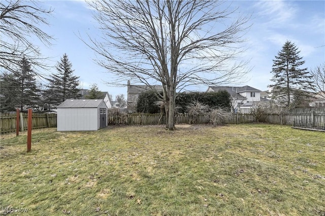 view of yard with a fenced backyard, a storage unit, and an outdoor structure