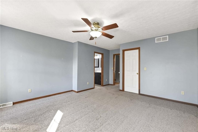 empty room with a textured ceiling, ceiling fan, visible vents, and baseboards