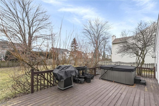 wooden deck with fence, a hot tub, and area for grilling