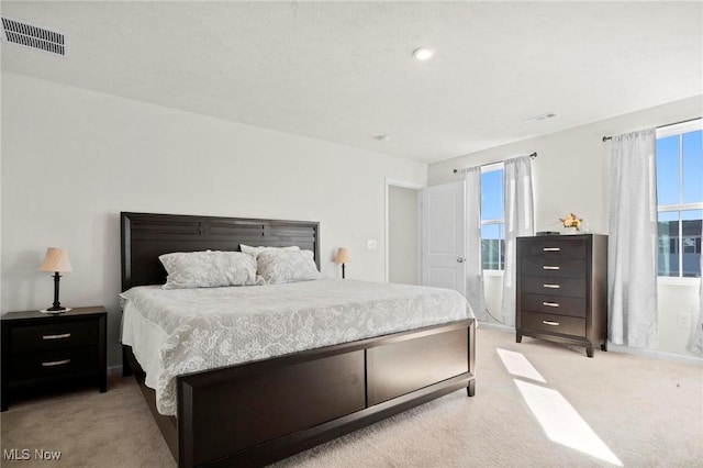 bedroom featuring light carpet and visible vents