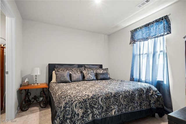 carpeted bedroom featuring visible vents