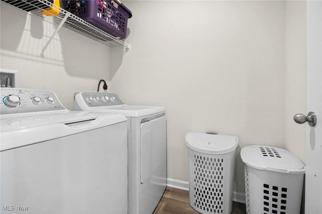 washroom featuring laundry area, baseboards, separate washer and dryer, and dark wood-style flooring