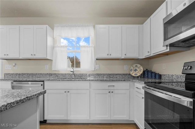 kitchen with stainless steel appliances and white cabinetry