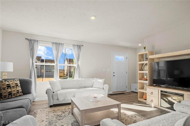 living room with light wood-type flooring, baseboards, and recessed lighting