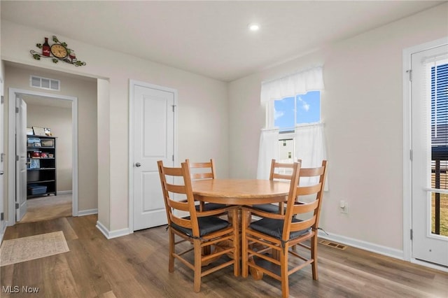 dining area with visible vents, baseboards, and wood finished floors