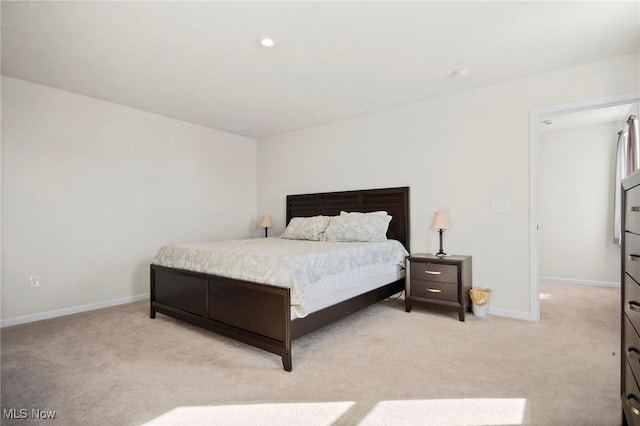 bedroom with light carpet and baseboards