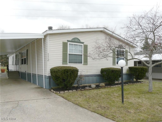 view of property exterior with entry steps, a yard, and driveway