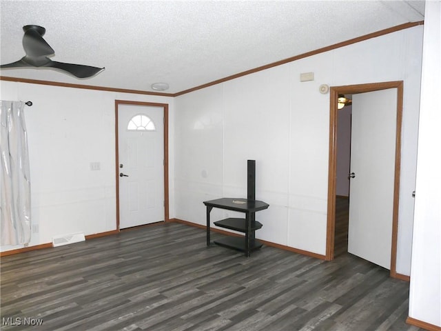 entryway featuring dark wood-style flooring, visible vents, crown molding, and a textured ceiling