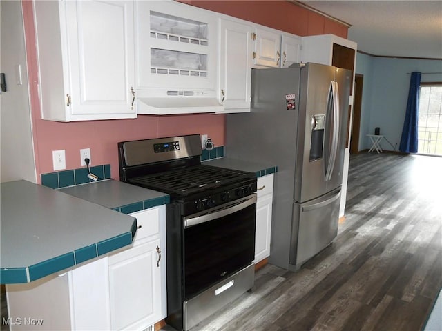 kitchen with dark wood-style floors, appliances with stainless steel finishes, ventilation hood, and white cabinets