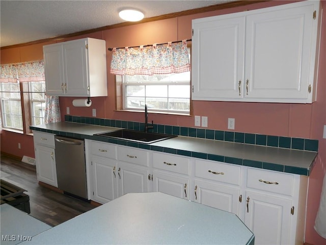 kitchen with plenty of natural light, white cabinetry, dishwasher, and a sink