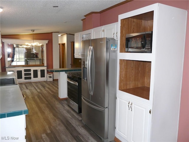 kitchen with dark wood finished floors, hanging light fixtures, appliances with stainless steel finishes, white cabinets, and a textured ceiling