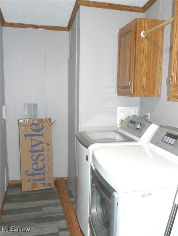 laundry room with a textured ceiling, washer and clothes dryer, wood finished floors, and cabinet space