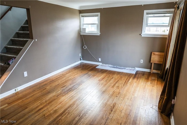 basement featuring wood-type flooring, baseboards, and stairs