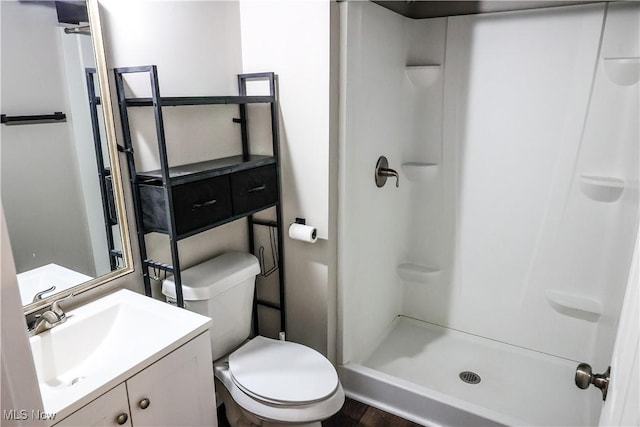 full bath featuring toilet, a shower stall, and vanity