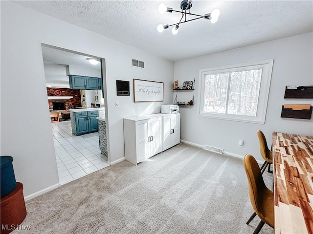 washroom featuring visible vents, light carpet, a textured ceiling, and an inviting chandelier