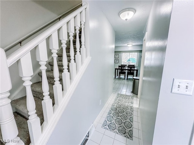 hall with stairway and tile patterned flooring