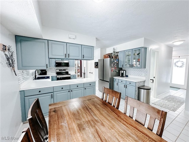 interior space featuring light tile patterned floors, a textured ceiling, and baseboards