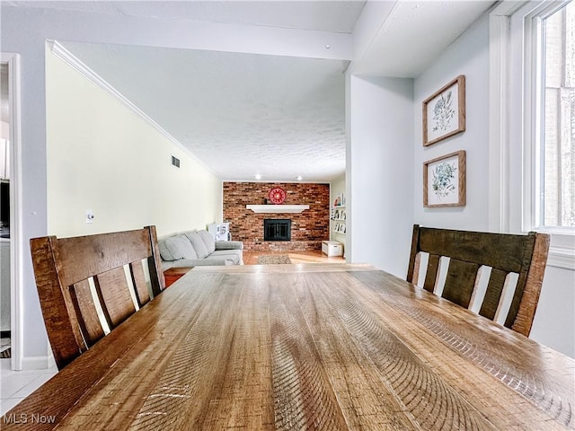 unfurnished dining area with ornamental molding, a fireplace, and visible vents