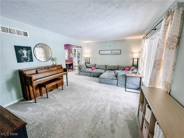 carpeted living room featuring a textured ceiling, visible vents, and baseboards